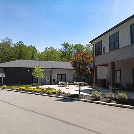The exterior of Vitalia Highland Heights, landscaped with flower beds and trees.